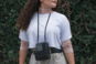 woman in white crew neck t-shirt and gray denim jeans standing beside green plant